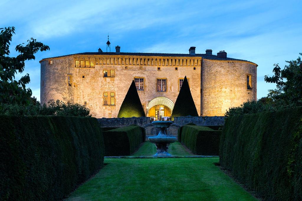 The moated walls of the château above the vineyards of Beaujolais.