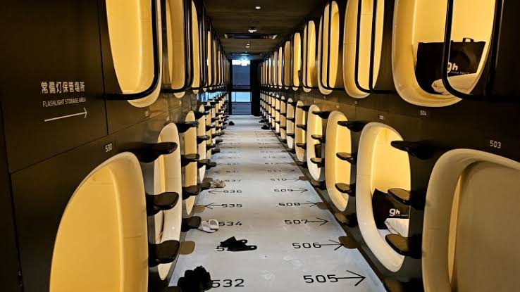 Capsule mouths in a plain white corridor near Hakata Station.